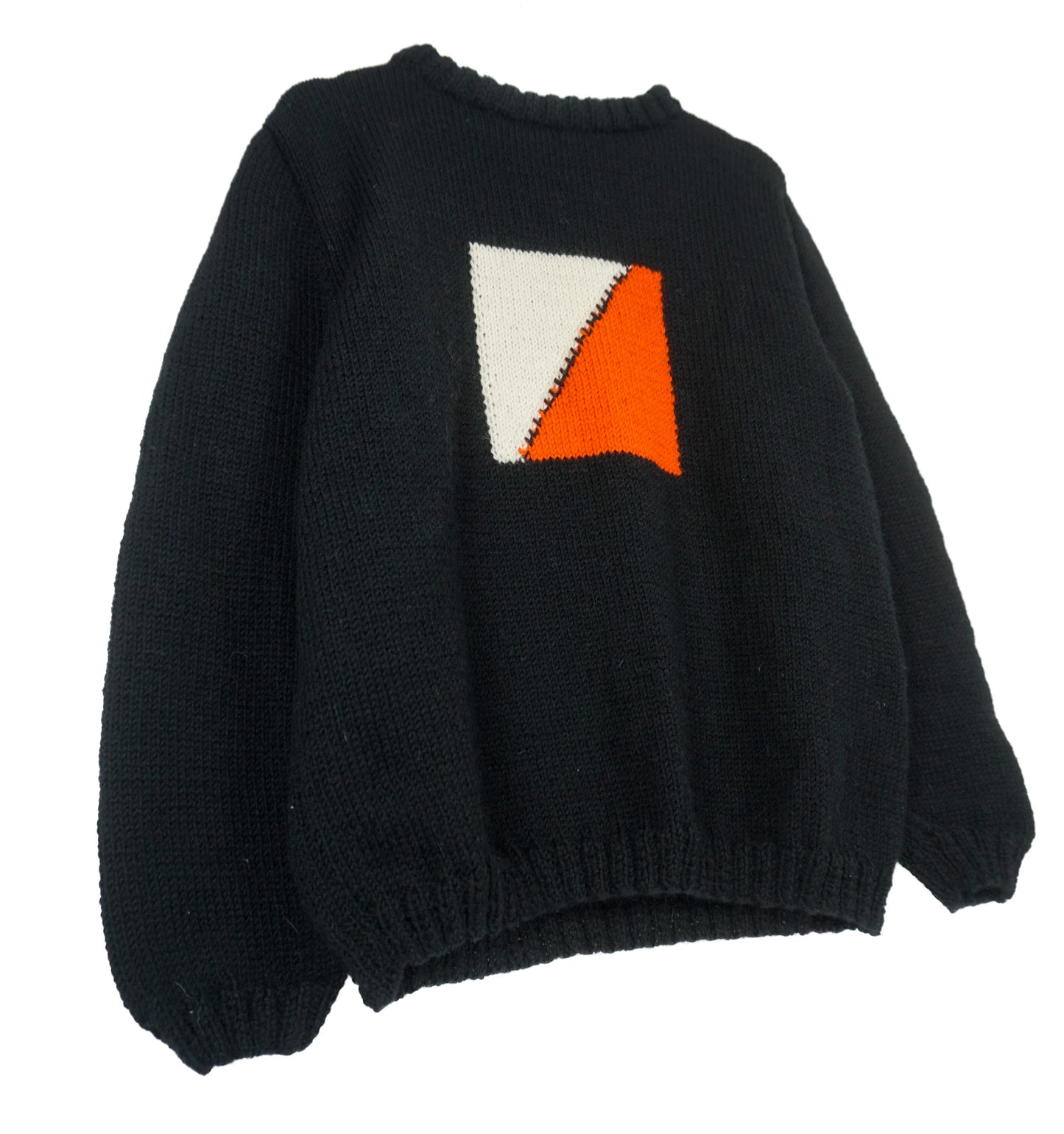 A black medium jumper with orange beige square pattern on it.