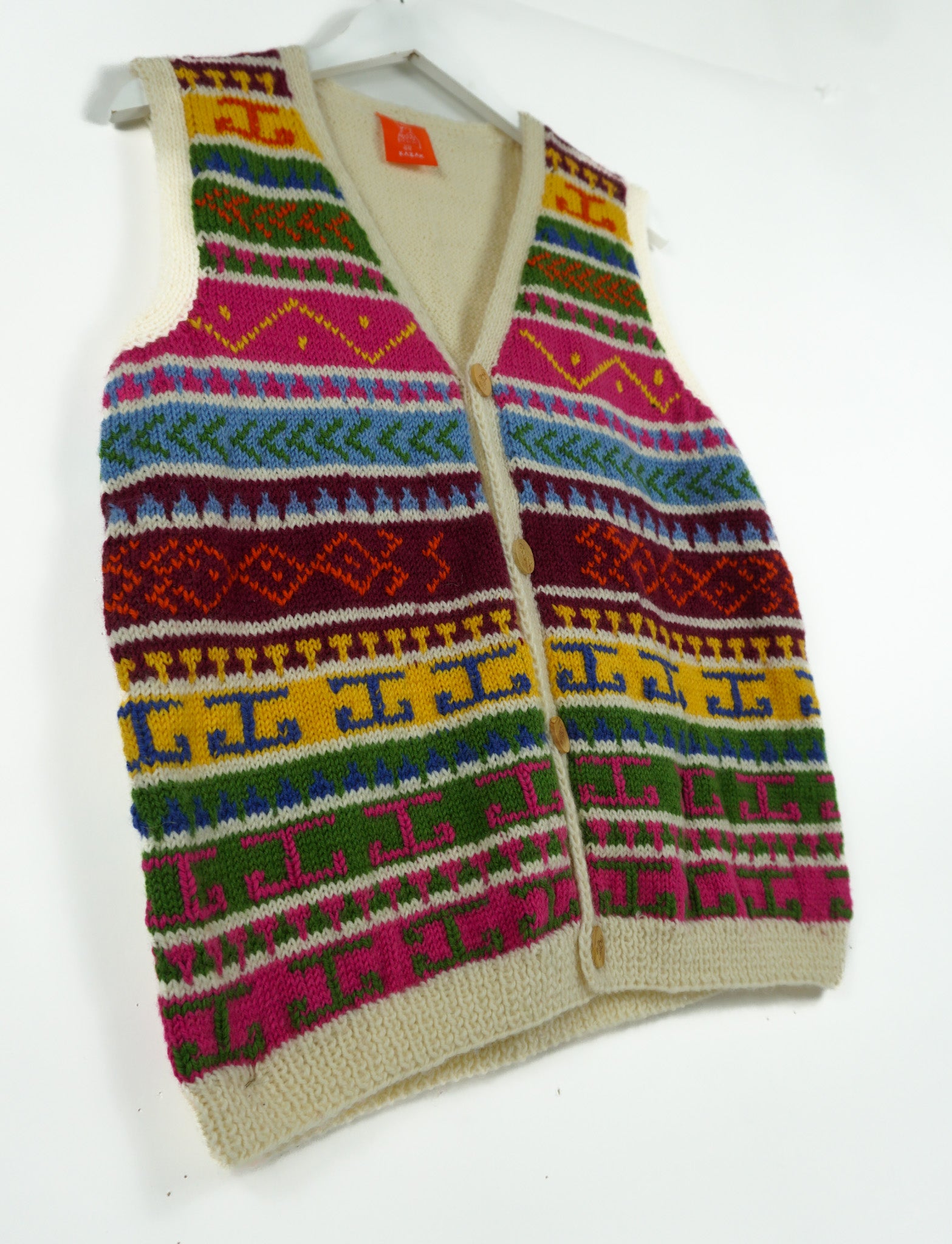 Hand knitted cardigan with heritage pattern on a white background