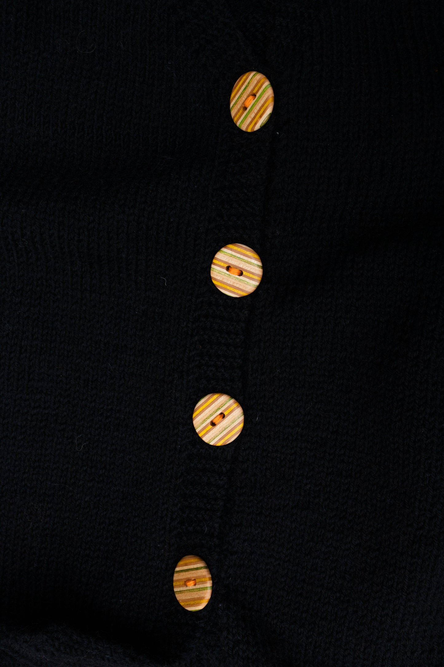 Recycled Skatebord Buttons on a black knitted vest, one of vest