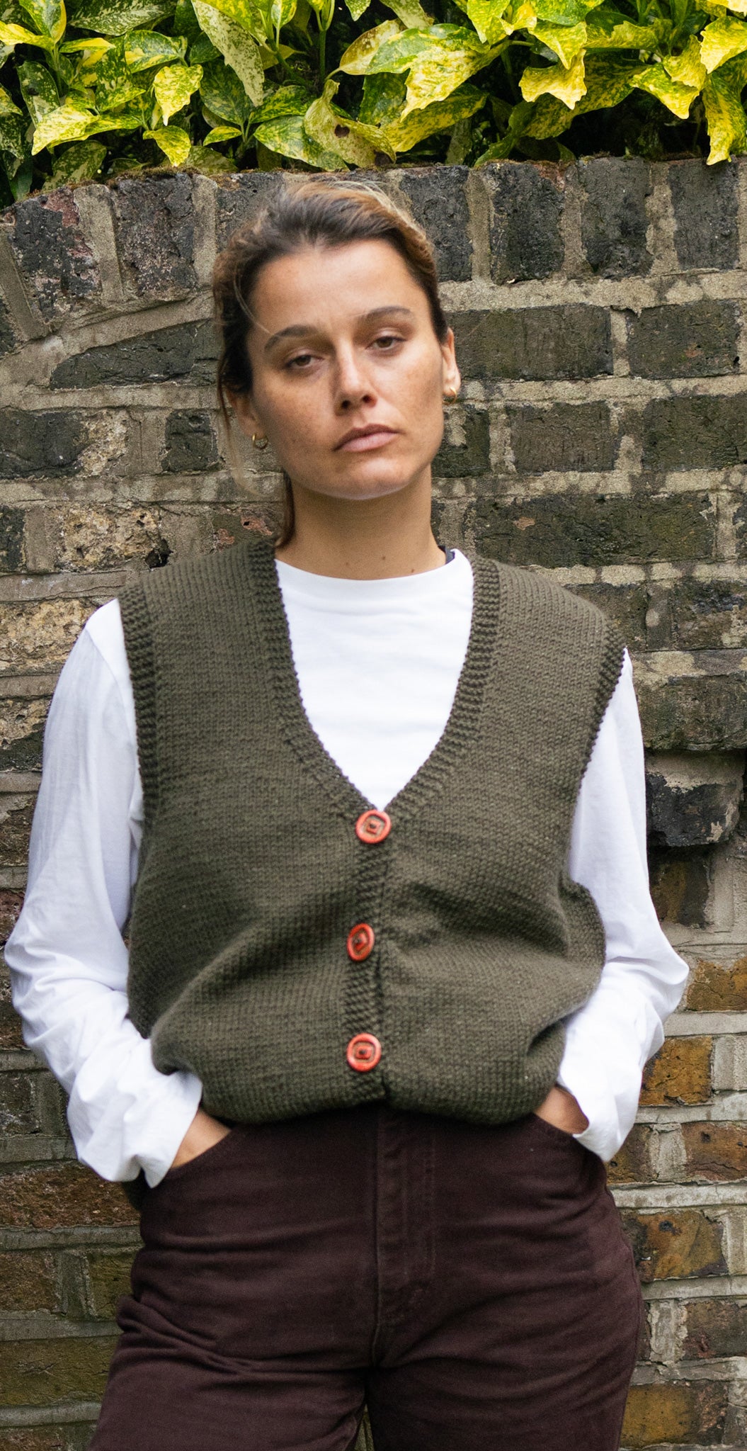 Khaki Red Button Sleeveless Cardigan, one-off hand-knitted sleeveless cardigan by Kazak Woolies, worn by a model