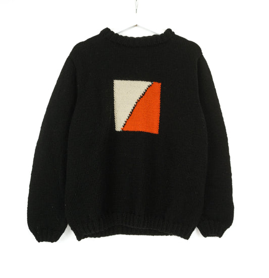 A black medium jumper with orange beige square pattern on it. 