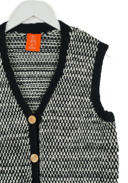 Black and white houndstooth patterned cardigan with orange tag on a white background