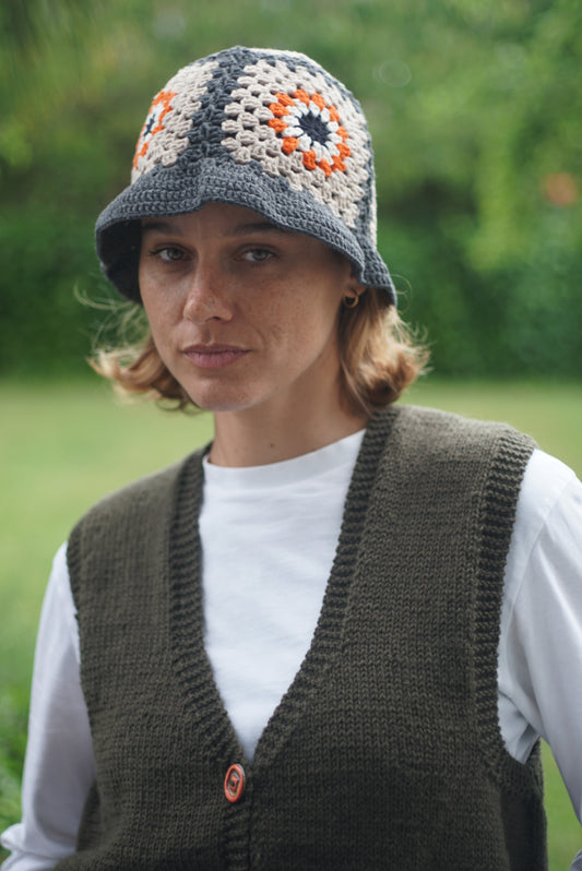 Hand Crochet cotton hat with orange floral patterns on it worn by a model, Glastonbury fashion, one off cotton hat