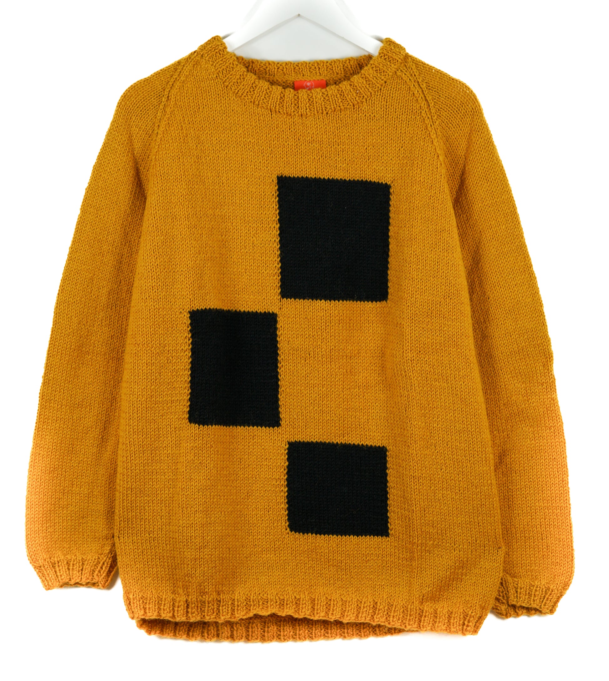 Yellow sweater with black square pattern on a white background