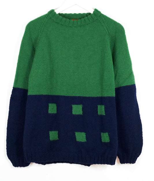 Green and navy sweater with square pattern on a white background