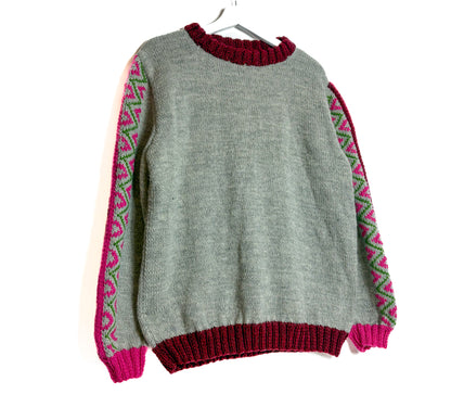 Gray sweater with red and pink patterned sleeves on a white background