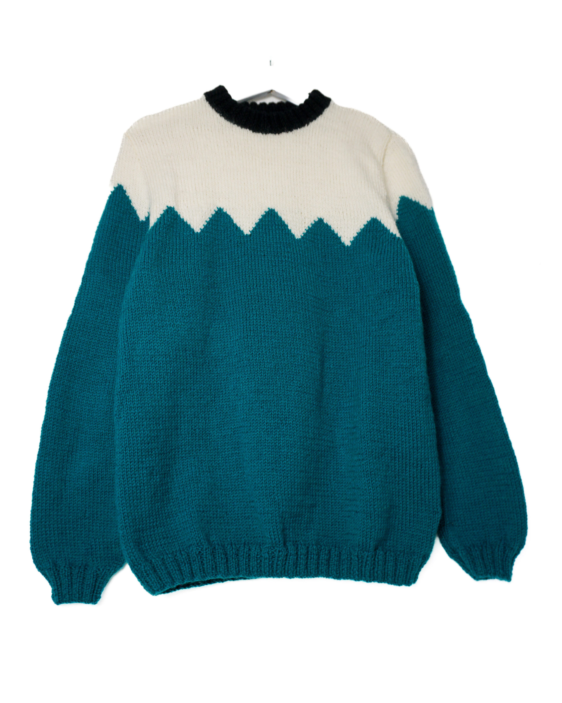 Teal and white sweater with a geometric pattern on a white background
