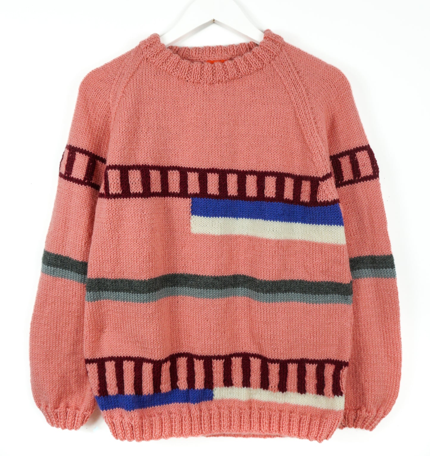 Pink sweater with colorful horizontal stripes on a white background