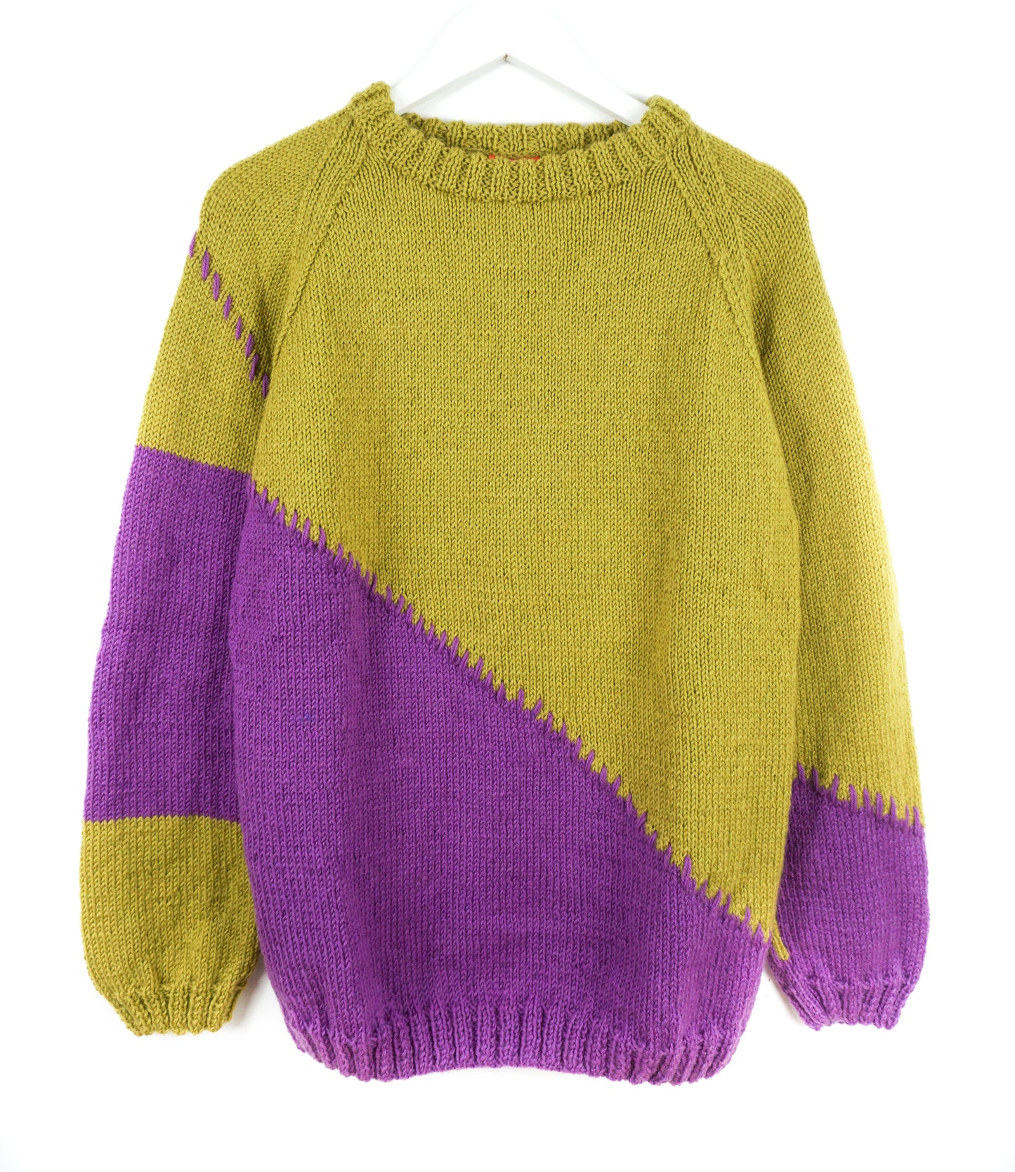 Color-blocked sweater with purple and green sections on a white background