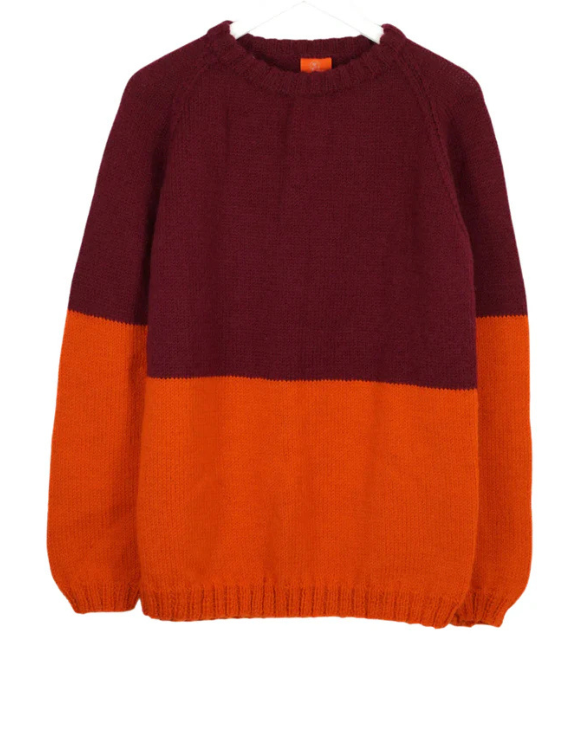 Two-tone maroon and orange sweater on a white background
