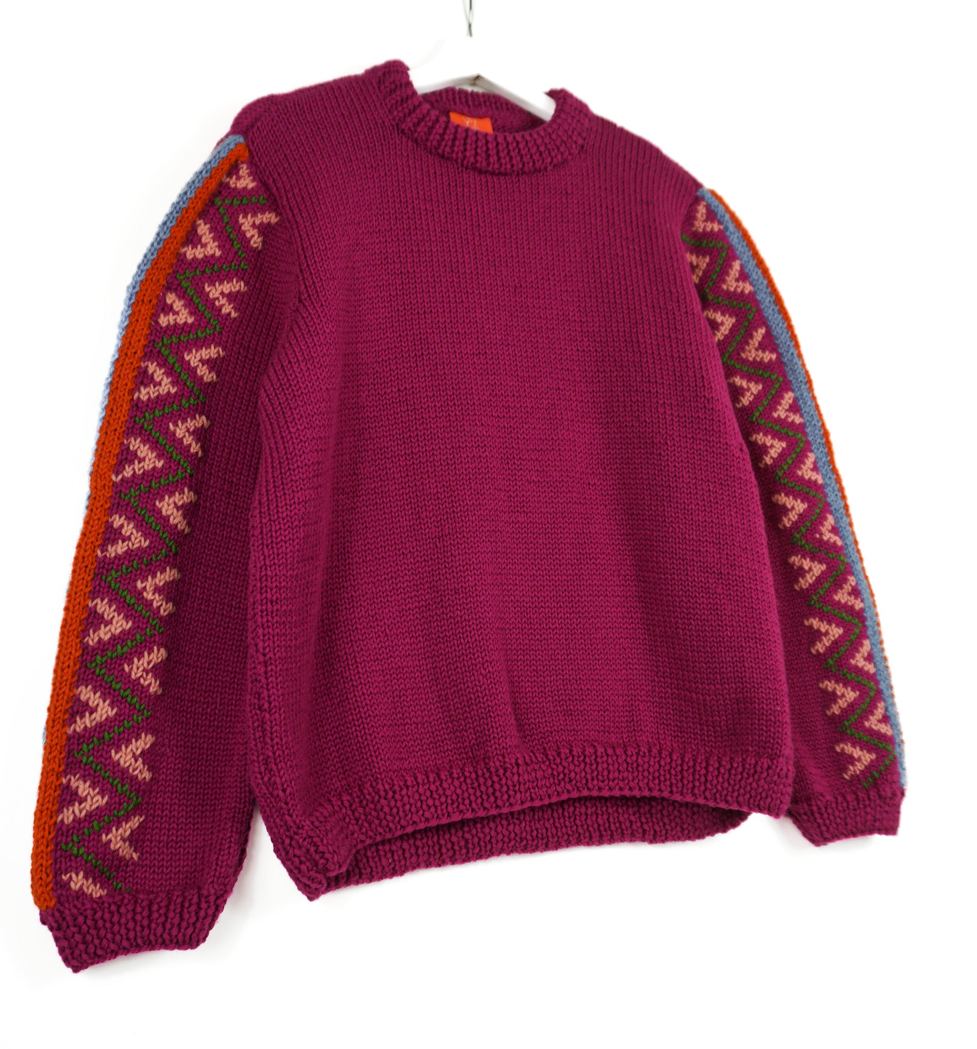 Purple Jumper with heritage style patterns on its arms, white background