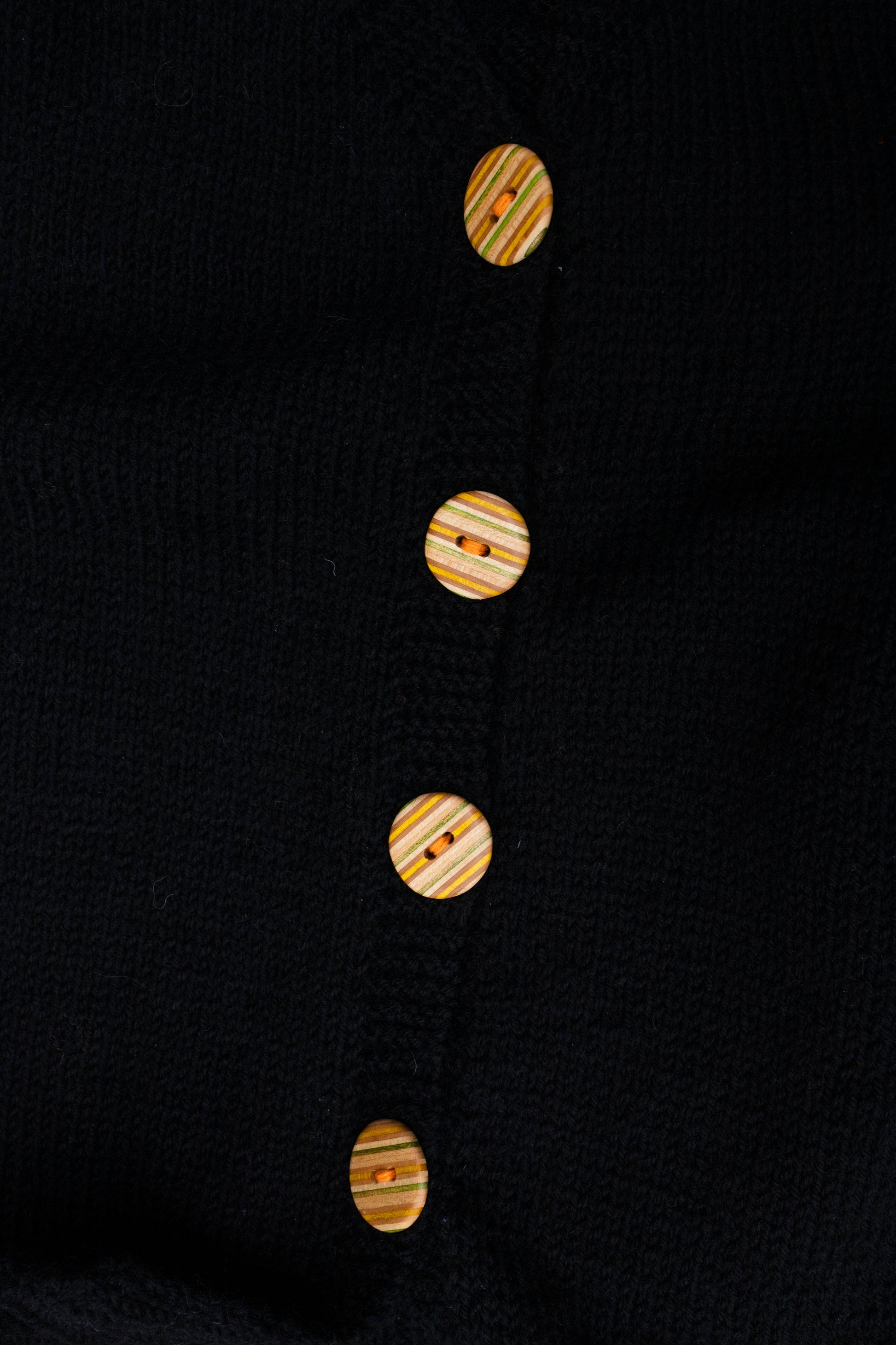 Recycled Skatebord Buttons on a black knitted vest, one of vest
