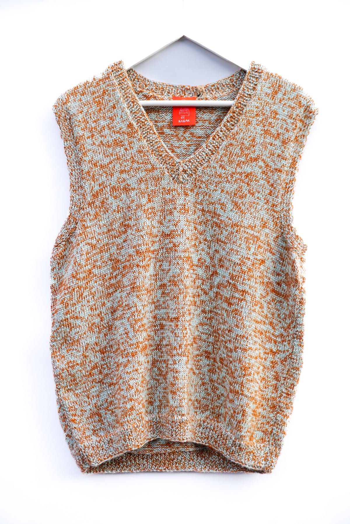 A sleeveless knit sweater vest with a V-neck, featuring a marled pattern of orange and light gray, hanging on a white hanger against a white background.