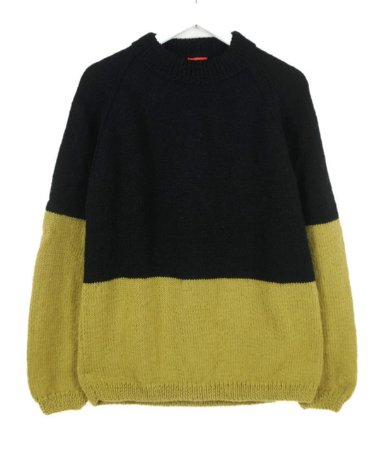 Black and mustard yellow sweater on a white background