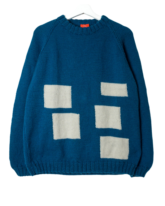 Blue sweater with white square patterns on a white background