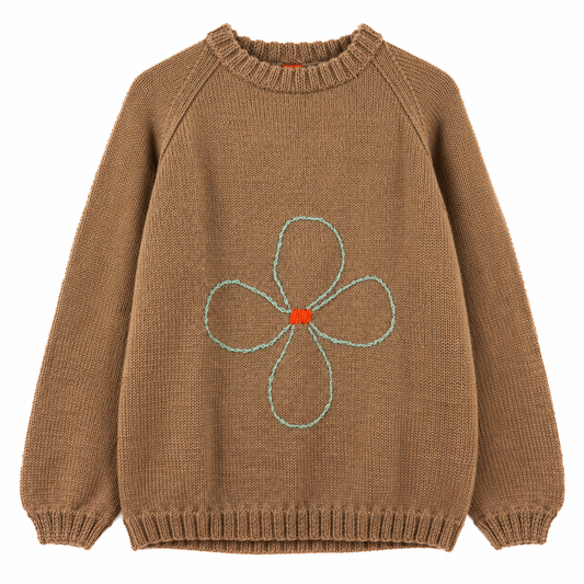Light brown jumper with a flower knitted on it, over a white background