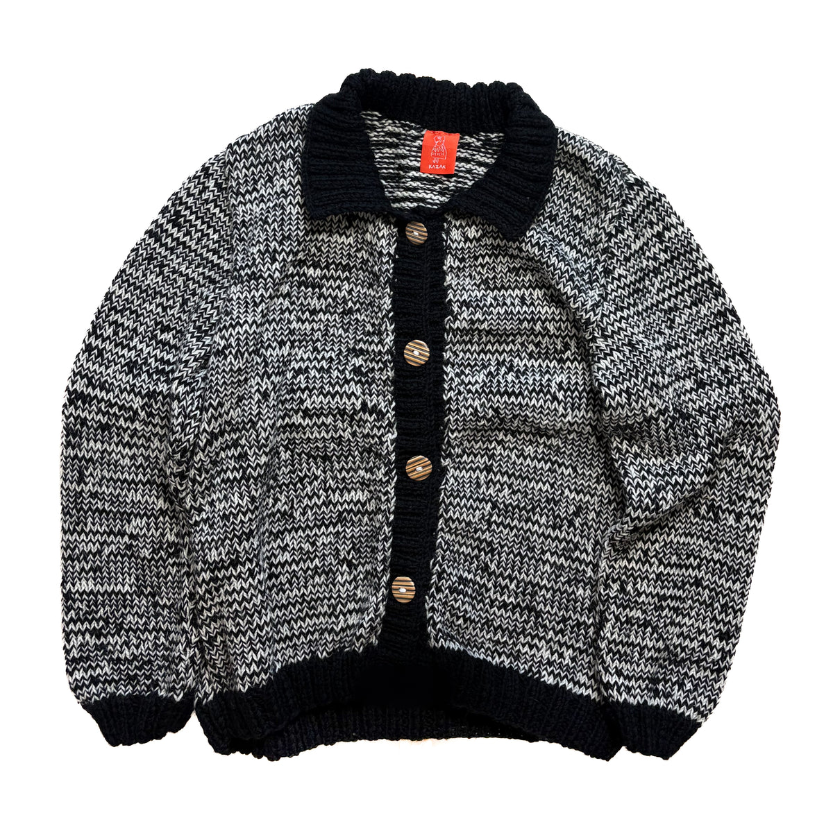 A black and white marled knit cardigan sweater with a solid black ribbed collar, button placket, and hem, featuring brown buttons, shown flat on a white background.