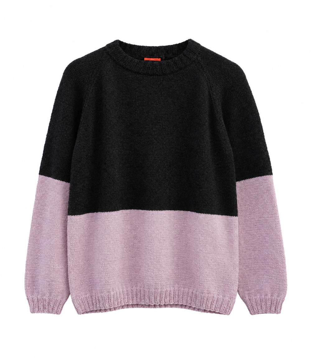 A colorblock knit sweater with a black upper body and light pink lower body and sleeves, shown against a plain white background.