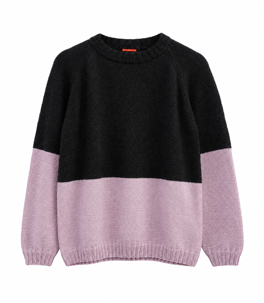 A colorblock knit sweater with a black upper body and light pink lower body and sleeves, shown against a plain white background.