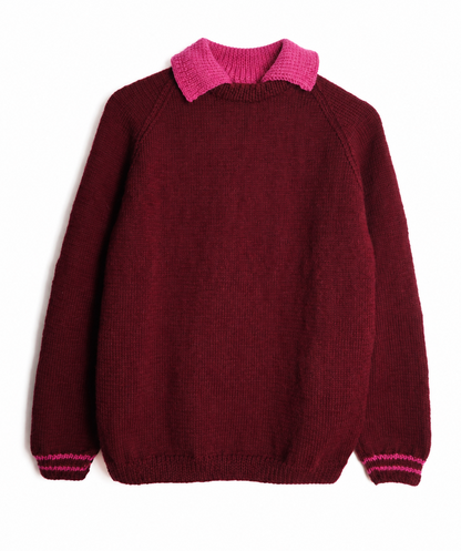 A dark burgundy knit sweater with a bright pink collar and matching pink stripes on the cuffs, displayed flat against a white background.